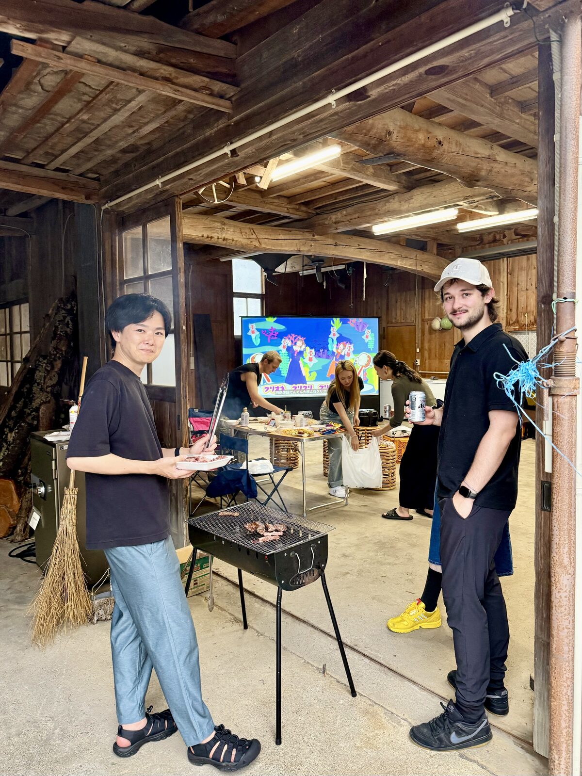屋根のある農業用倉庫で、仲間とBBQを楽しむ様子
