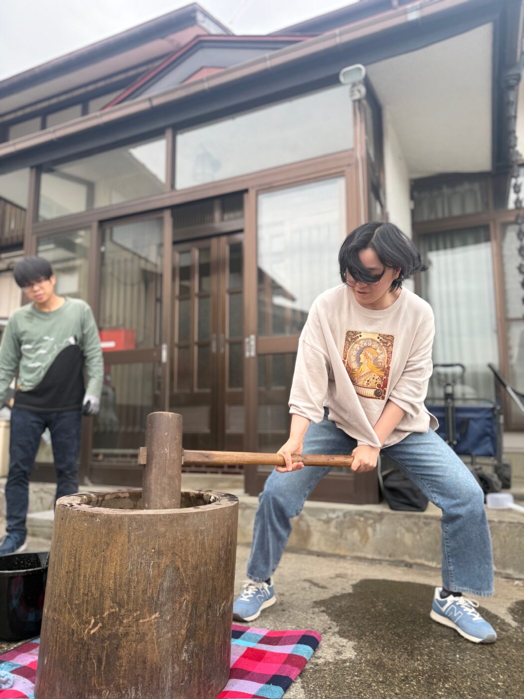杵を振り上げて、臼でお餅をつく様子