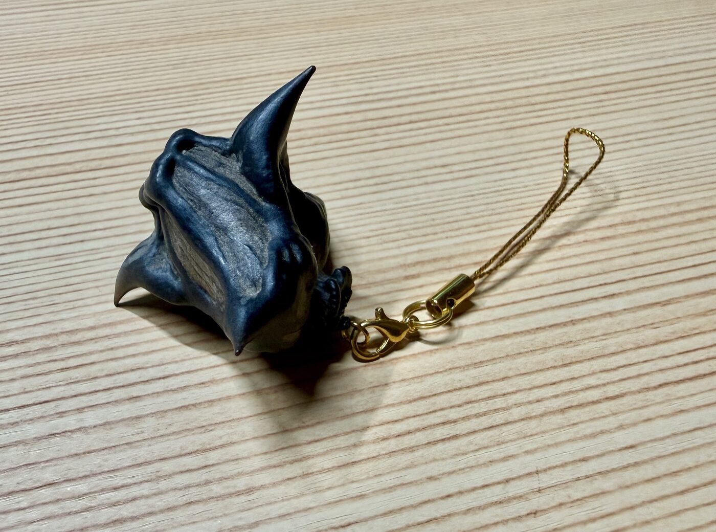 ヒシの実の殻で作った、金色のヒモつきのキーホルダー